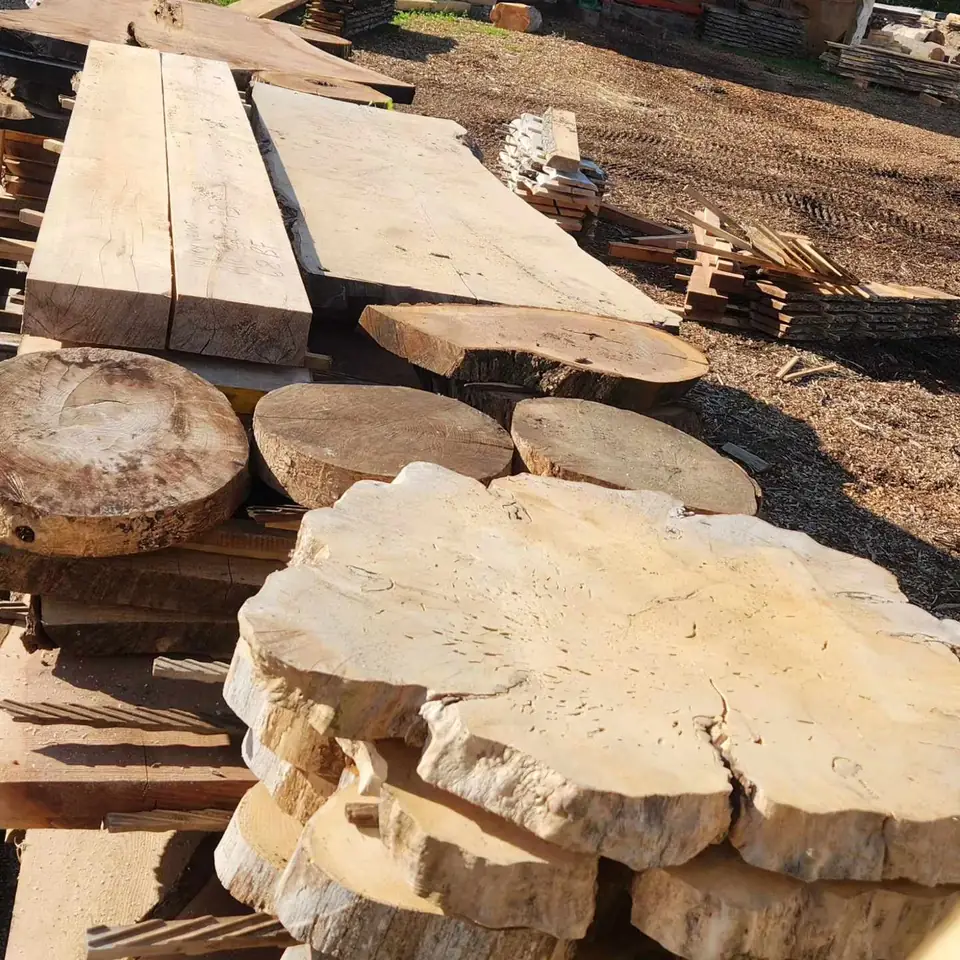 Rough-sawn slabs and round cookies stacked in the yard